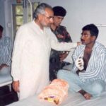 Naarendra Modi comforting an injured soldier at a base camp hospital during the Kargil War in 1999