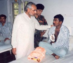 Naarendra Modi comforting an injured soldier at a base camp hospital during the Kargil War in 1999