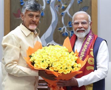 Andhra pradesh Chief Minister presenting a bouquet of yellow roses to Prime Minister Narendra Modi