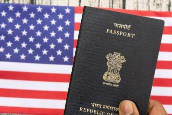 Inidan Passport and US flag in the background. US Visa