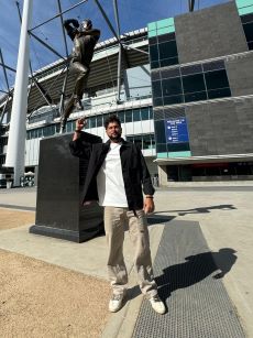 Cricketer Kuldeep Yadav posing in front of Shane Warne's statue at Melbourne Cricket Ground