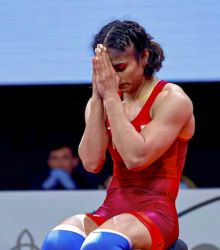 Vinesh Phogat on the mat thanking after winning a bout of wrestling match