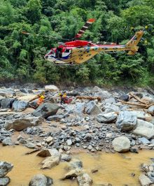 Rescue operation is underway after a devastating landslide triggered by heavy rainfall . Helicopter flying.